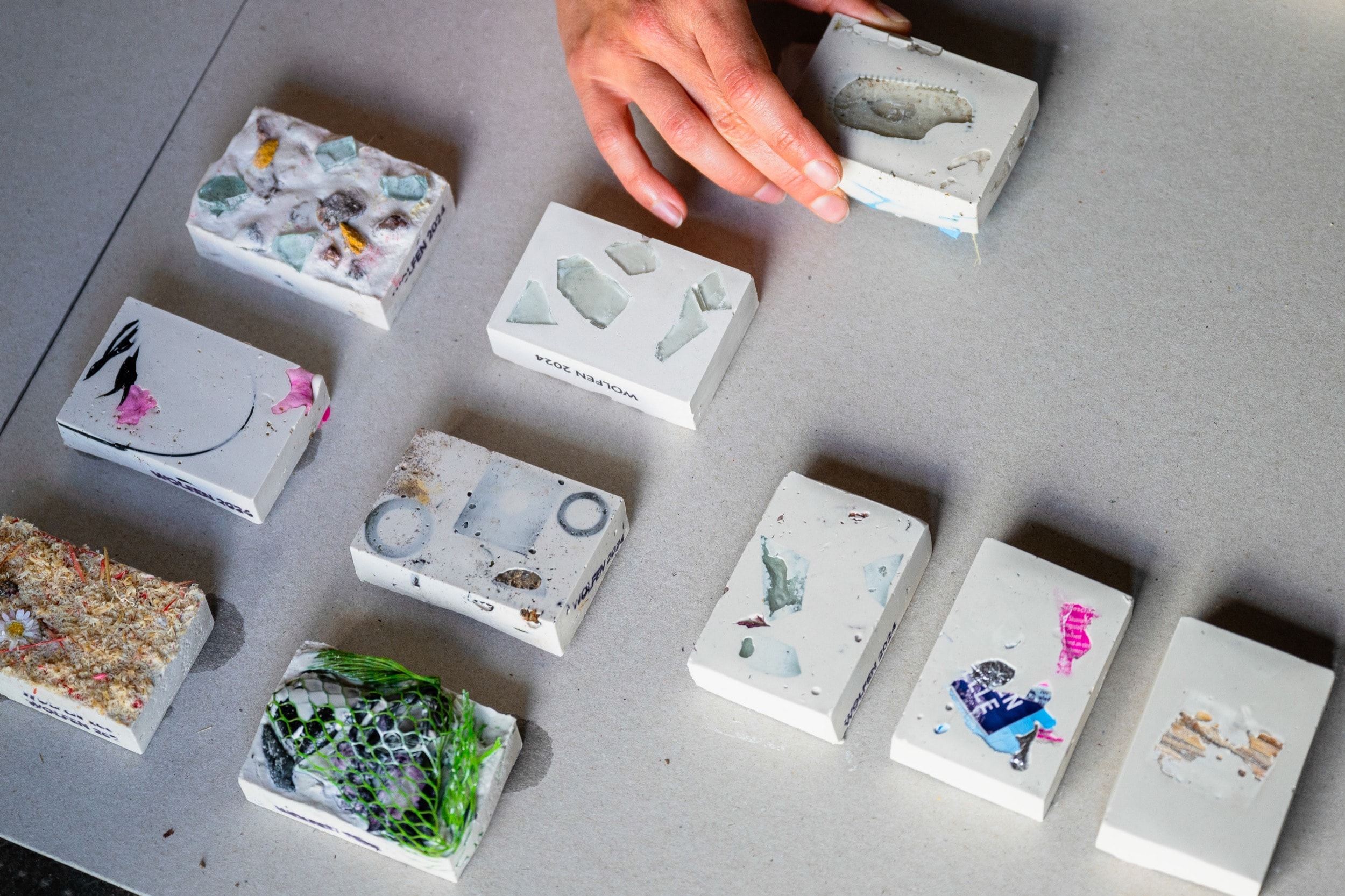 Hand arranging experimental material samples with embedded objects for design research study